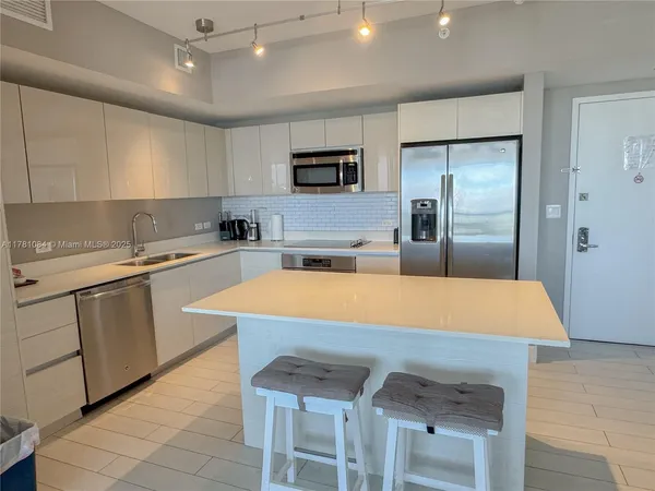 a kitchen with a sink a counter top space stainless steel appliances and cabinets