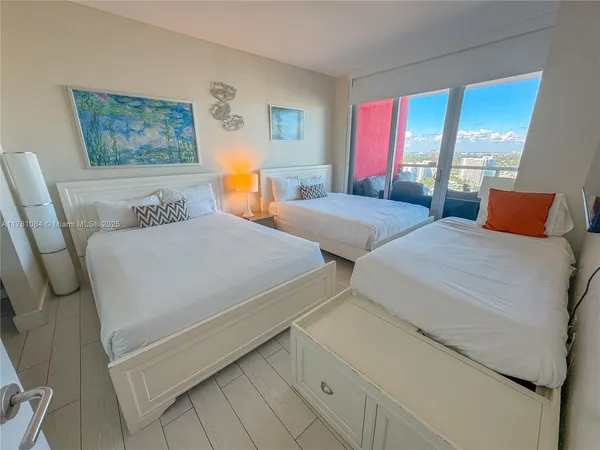 a bedroom with two beds and a large window