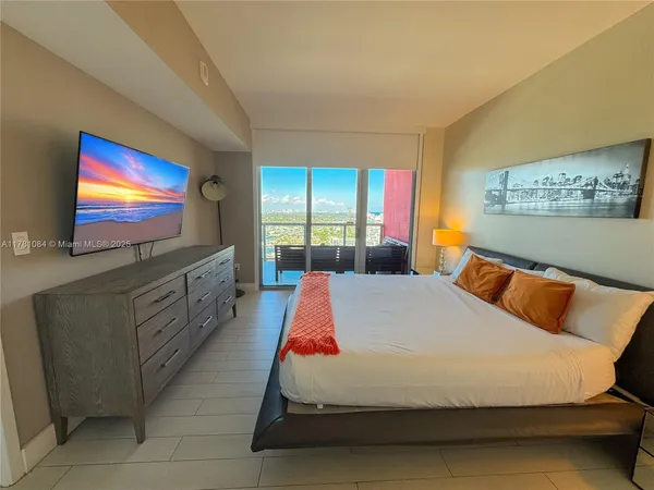 a bedroom with a bed and a flat screen tv