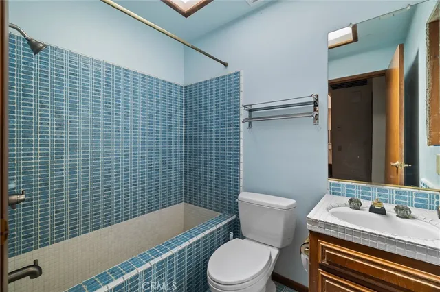 a view of an empty room with window and a kitchen