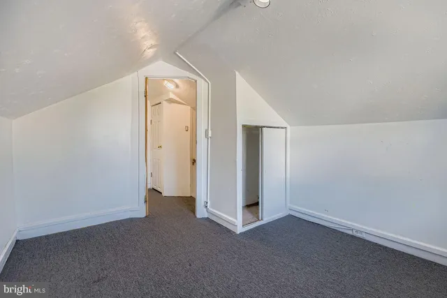 an empty room with closet and mirror