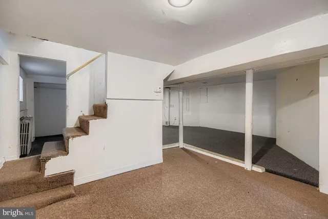 a view of a livingroom with wooden floor and staircase
