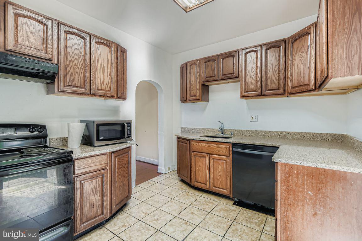 5710 Highgate Drive Baltimore, MD 21215 - Photo 10 of 28 a kitchen with stainless steel appliances granite countertop a stove sink and cabinets