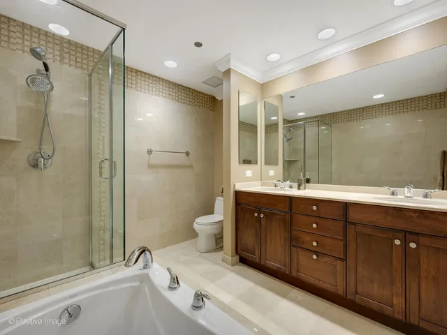 a bathroom with a tub sink shower and mirror