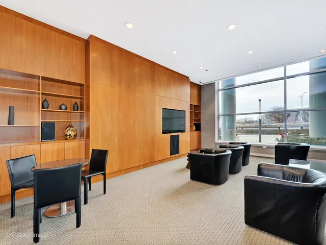 a living room with furniture a flat screen tv and a floor to ceiling window
