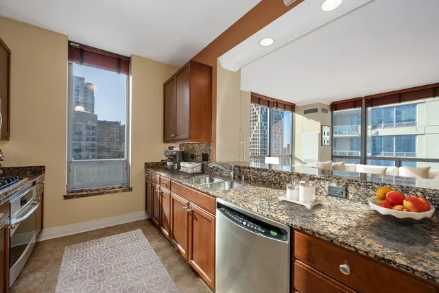 a kitchen with stainless steel appliances granite countertop a sink stove and cabinets