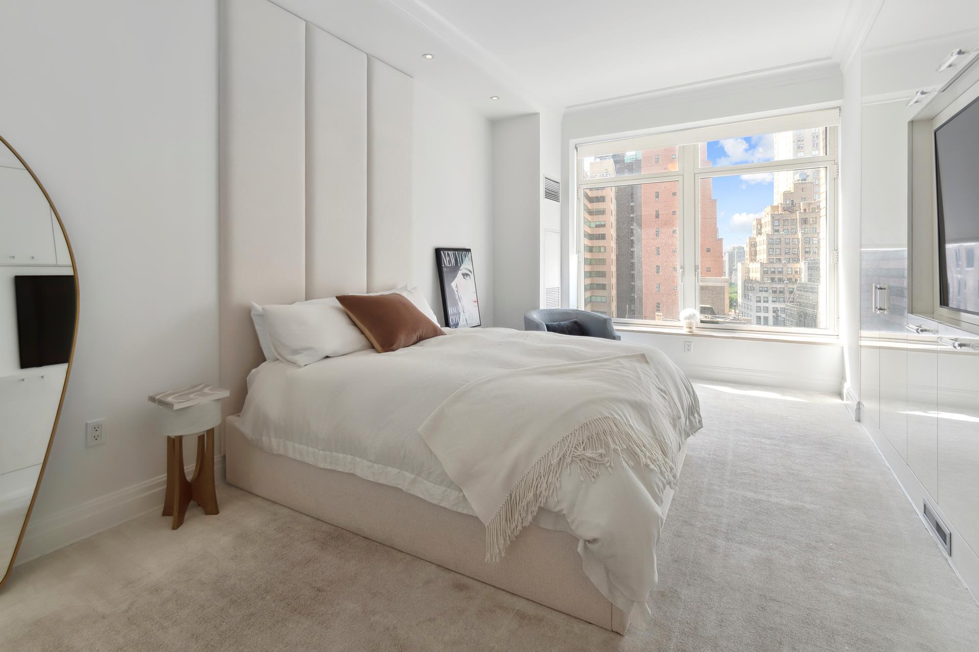 515 Park Avenue, Unit 19 Manhattan, NY 10022 - Photo 10 of 19 a bedroom with a bed and a flat tv screen next to a window