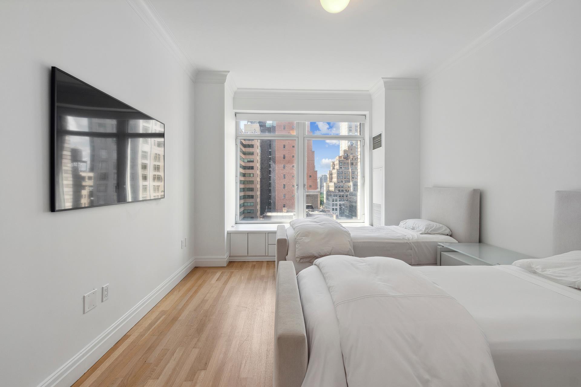 515 Park Avenue, Unit 19 Manhattan, NY 10022 - Photo 11 of 19 a bedroom with two beds and a large window