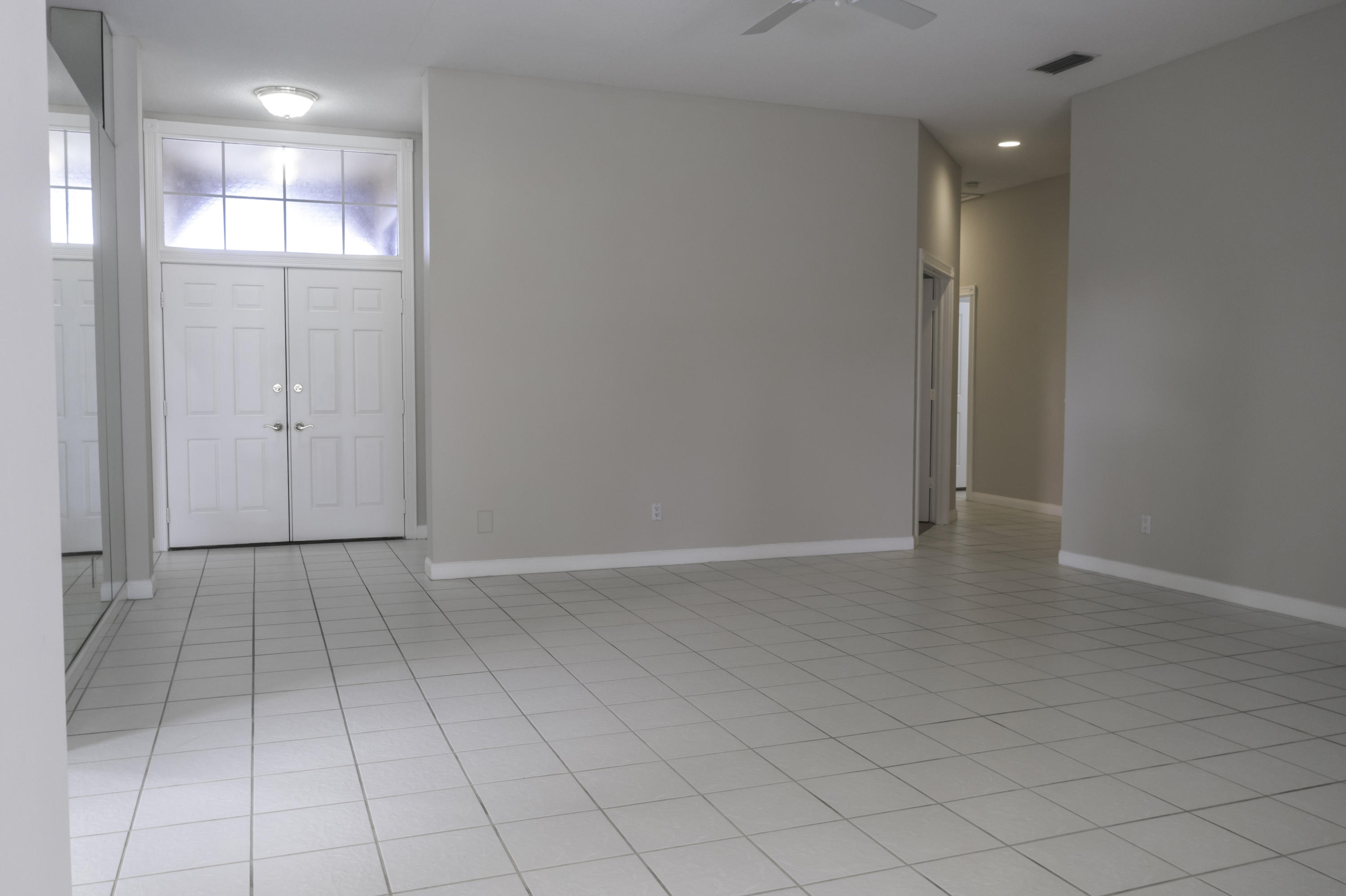 168 South Hampton Drive Jupiter, FL 33458 - Photo 2 of 21 an empty room with white walls and natural light