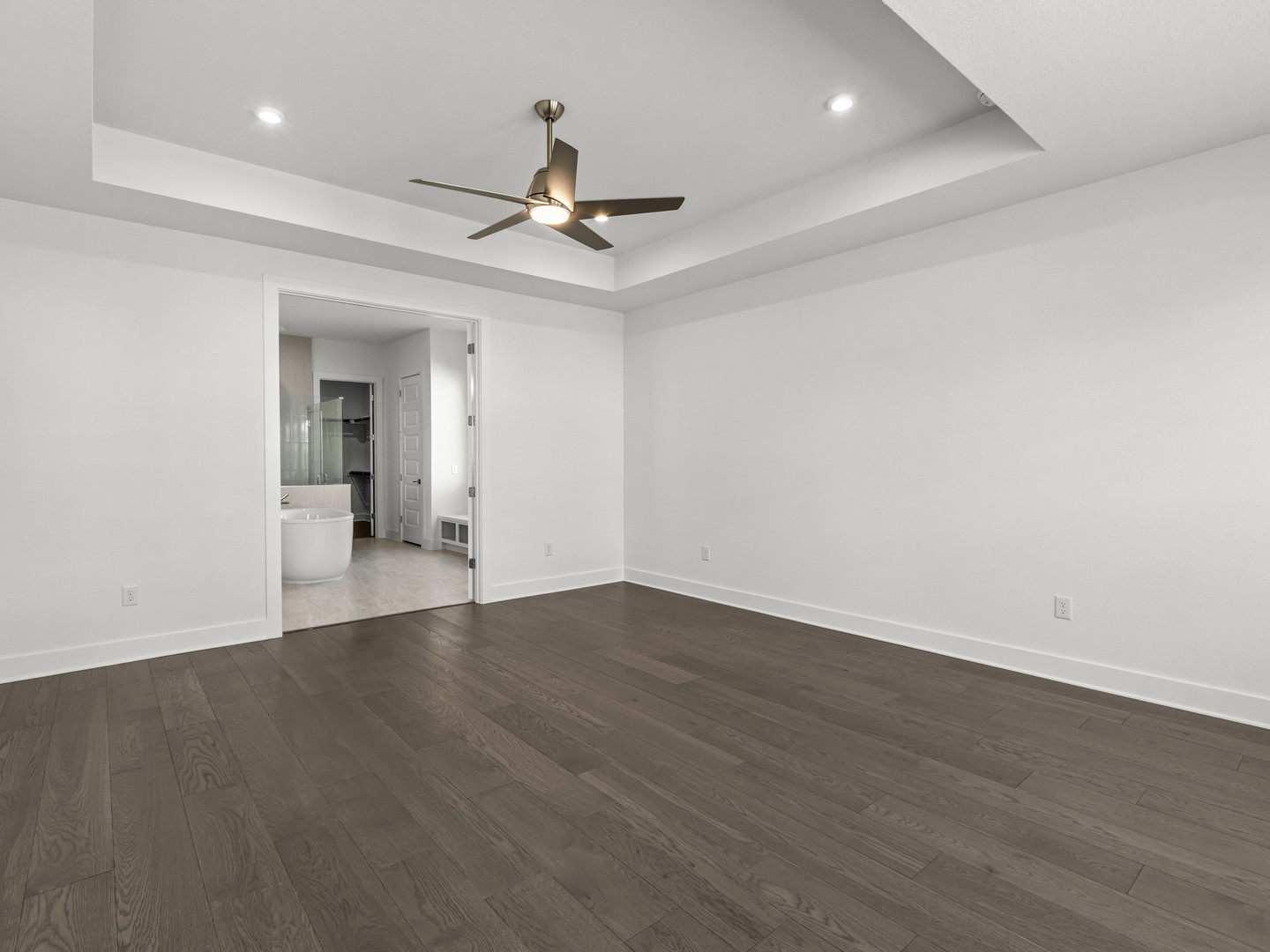 2508 Chiavari Way Leander, TX 78641 - Photo 22 of 24 Step into this spacious primary bedroom featuring rich hardwood flooring and a stylish ceiling fan.