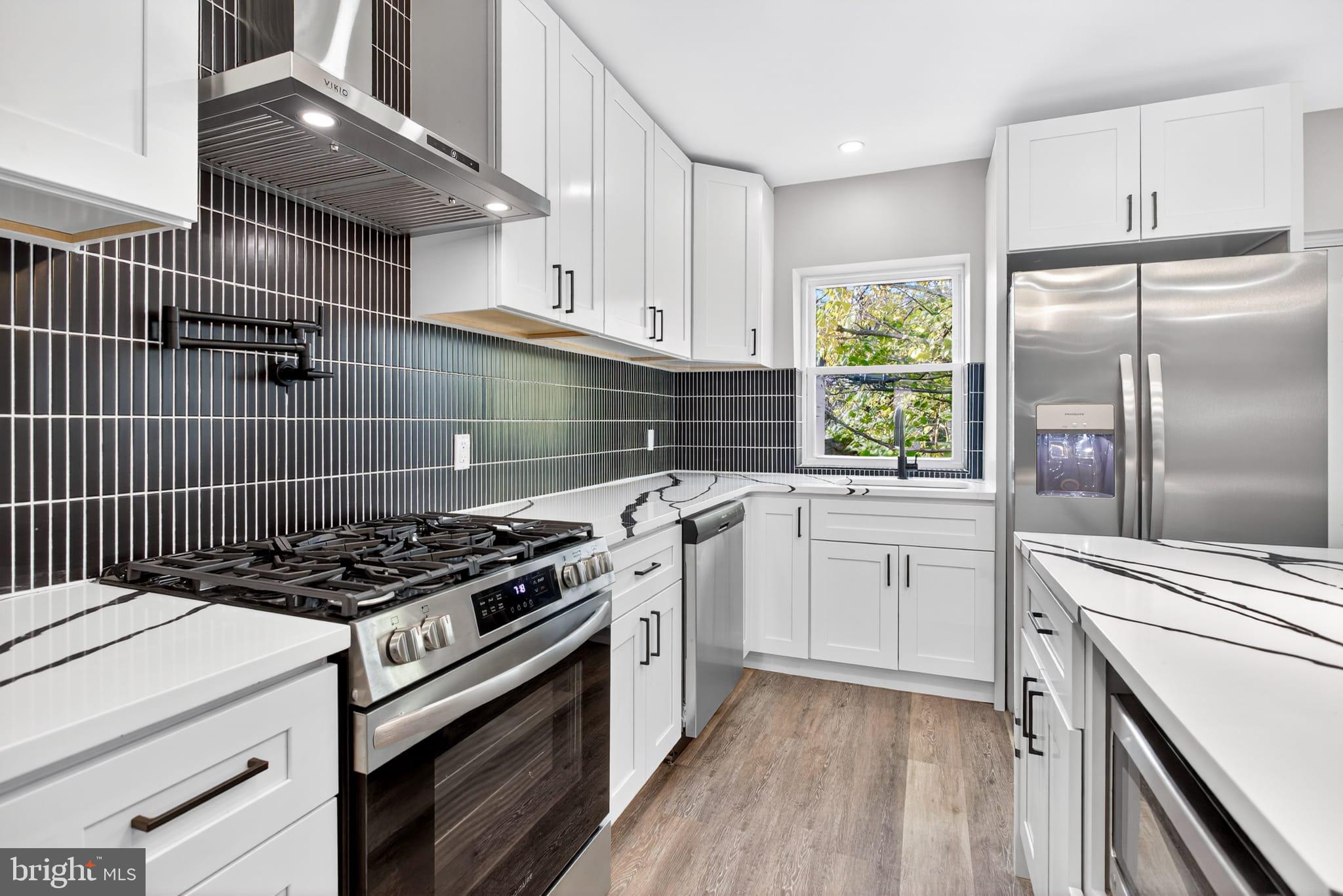 2658 South 68th Street Philadelphia, PA 19142 - Photo 11 of 36 a kitchen with cabinets appliances and a window