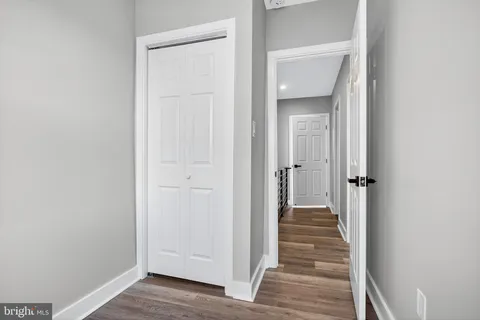 a view of a hallway with wooden floor and closet