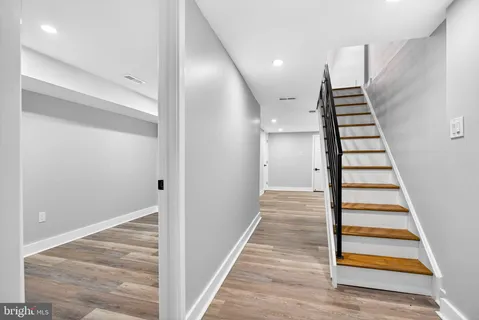 a view of a hallway with staircase and white walls