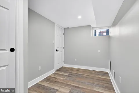 a view of a big room with wooden floor and windows