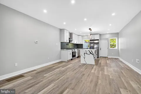 a kitchen with a table chairs microwave and cabinets