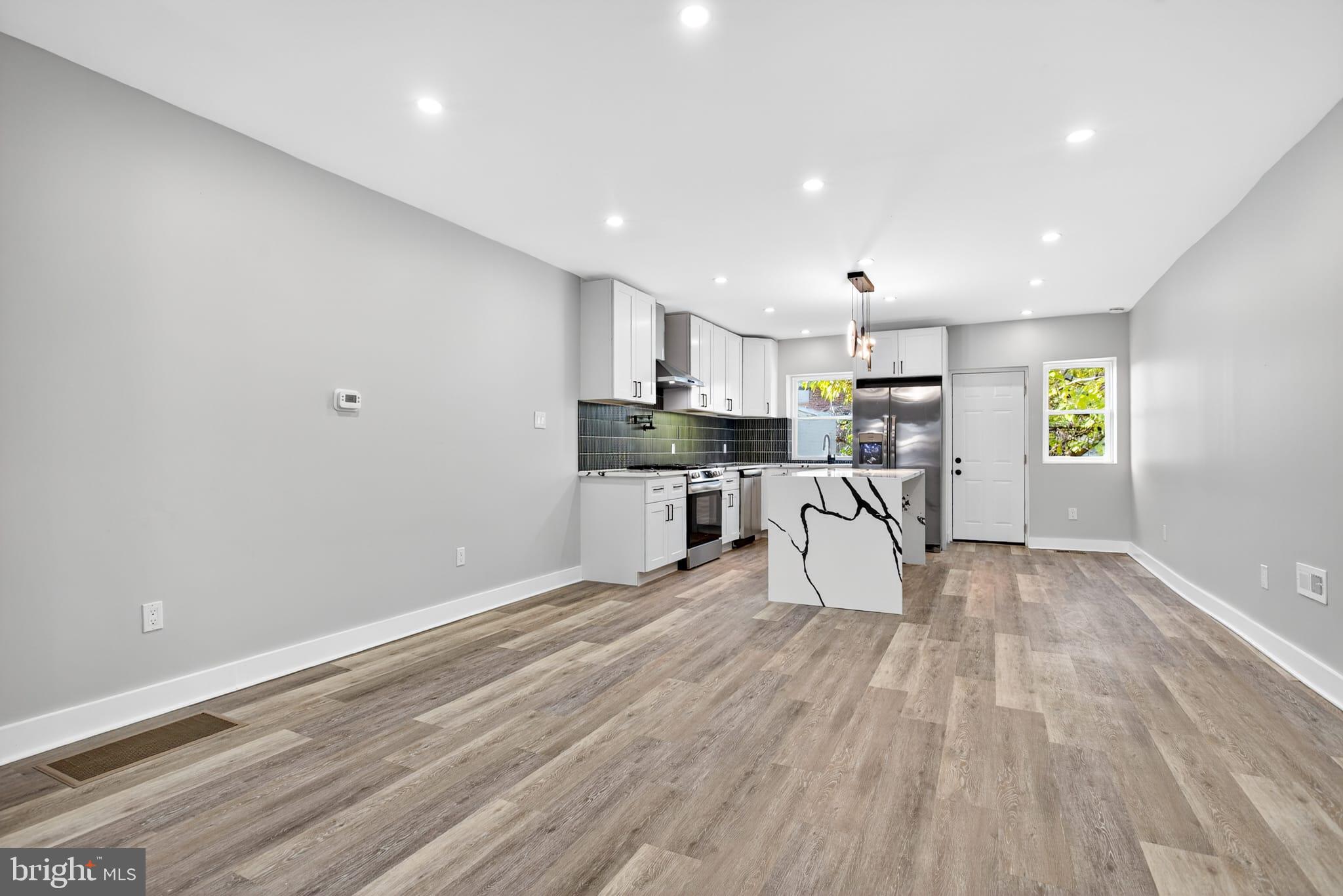 2658 South 68th Street Philadelphia, PA 19142 - Photo 7 of 36 a kitchen with a table chairs microwave and cabinets