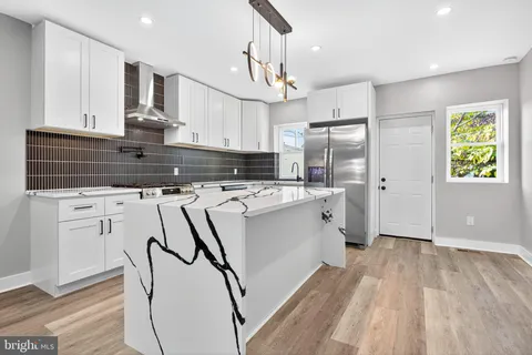 a kitchen with a refrigerator a sink and cabinets