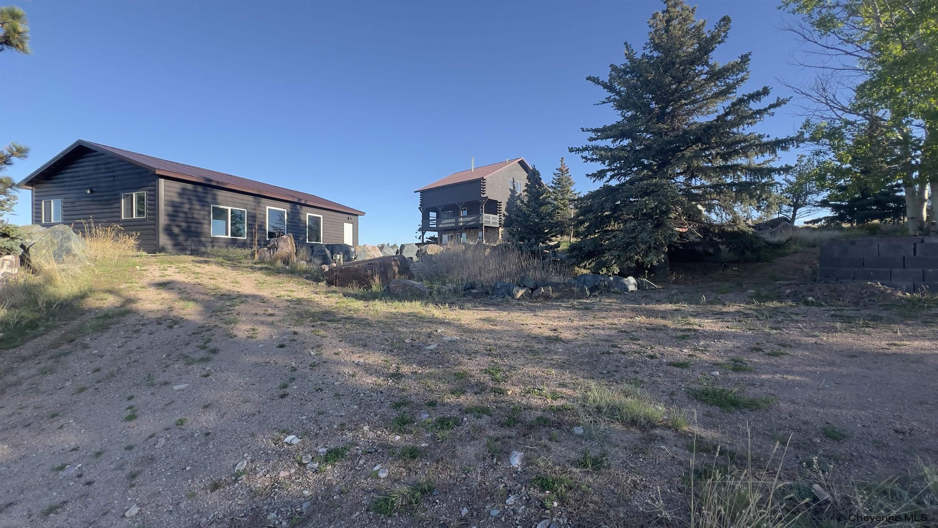 393 Happy Jack Road Cheyenne, WY 82009 - Photo 29 of 34 Here you can see the large pool house and log cabin from the driveway to the cliff houses. There is access from everywhere to get to any spot on the property.