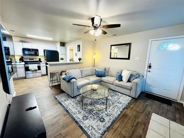 a living room with furniture and a wooden floor