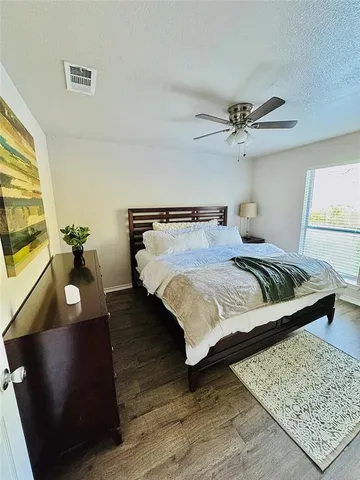 a bedroom with bed and a painting on the wall