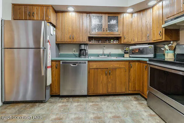 a kitchen with stainless steel appliances granite countertop a refrigerator a sink a stove a microwave and cabinets