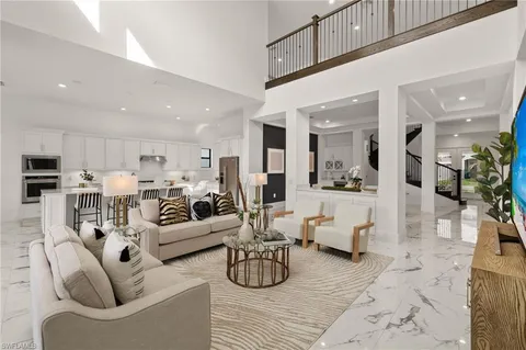a living room with furniture kitchen view and a chandelier