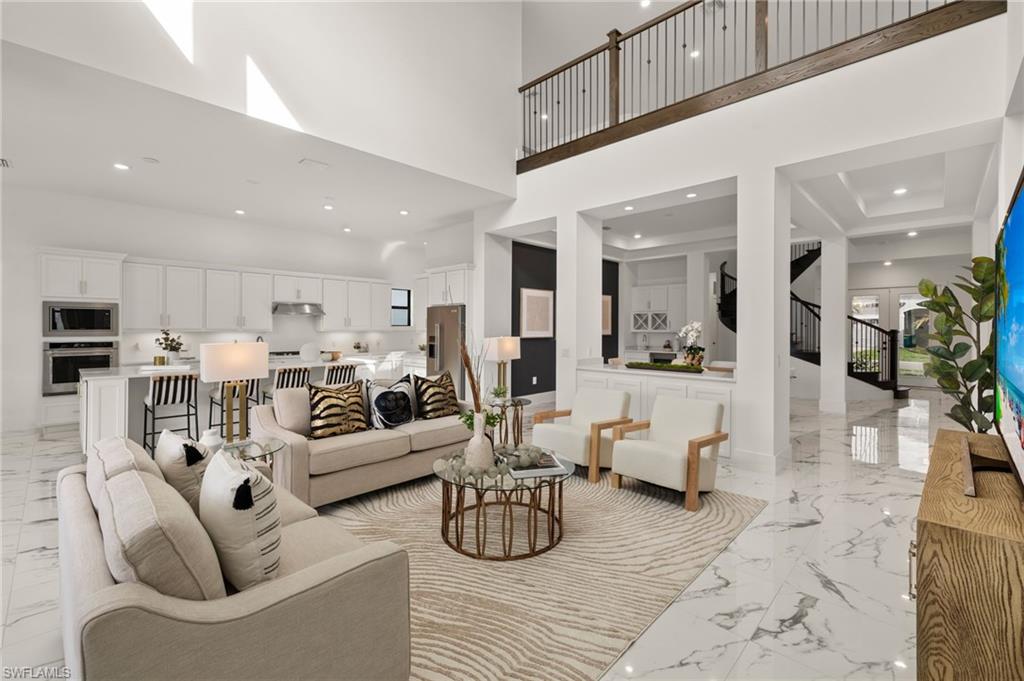 a living room with furniture kitchen view and a chandelier