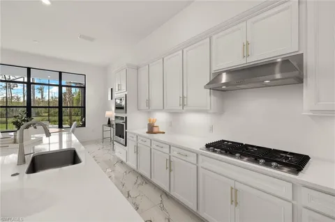 a kitchen with white cabinets and appliances