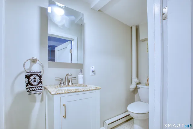 a bathroom with a granite countertop sink toilet and a mirror
