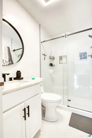 a bathroom with a granite countertop sink toilet and shower