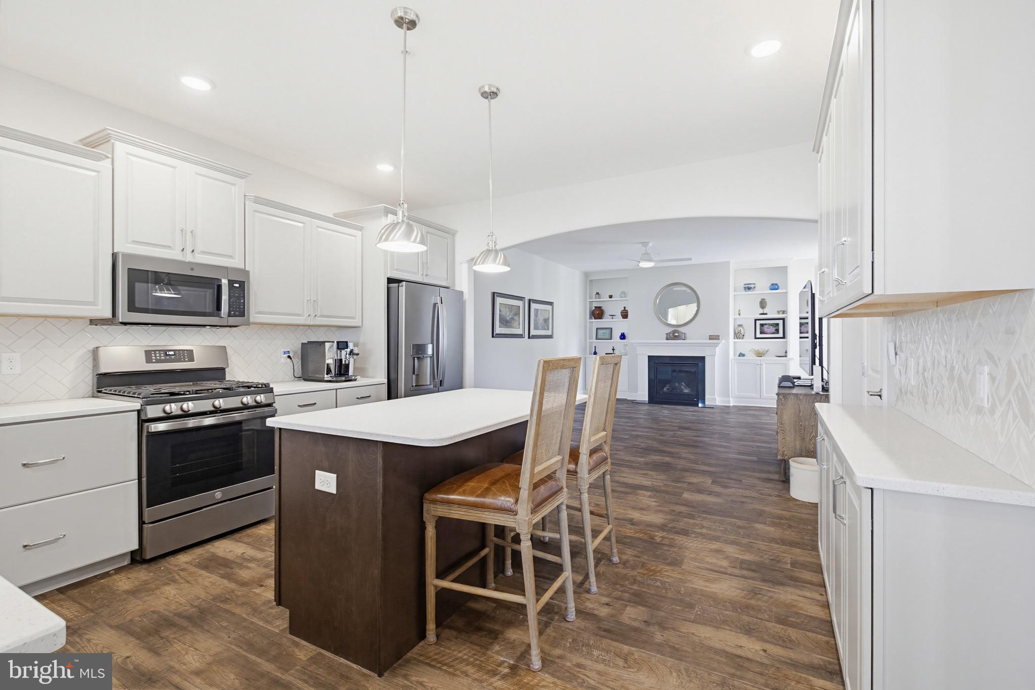 361 Meadow Rose Drive Lititz, PA 17543 - Photo 13 of 39 a kitchen with stainless steel appliances kitchen island granite countertop a stove top oven a sink dishwasher a dining table and chairs with wooden floor