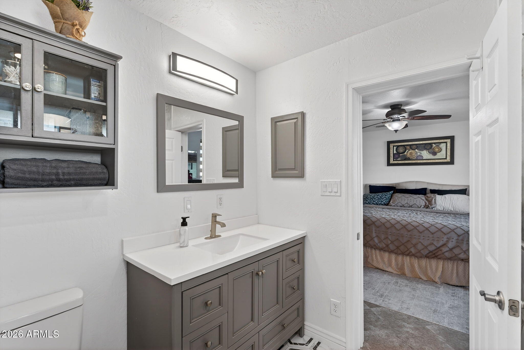 13202 West Ocotillo Road Glendale, AZ 85307 - Photo 25 of 58 a en suite bathroom with a sink a toilet and a mirror