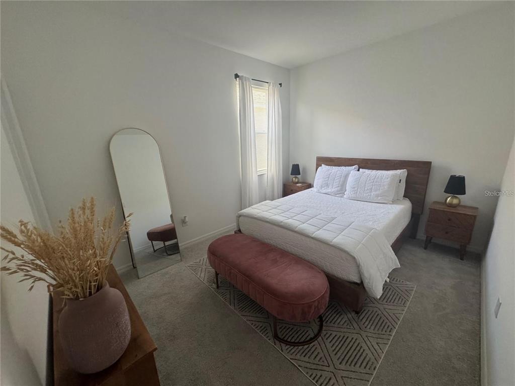 4356 Reisswood Loop Palmetto, FL 34221 - Photo 12 of 17 a bedroom with a bed a couch and dresser