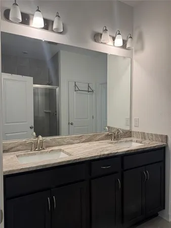 a bathroom with a double vanity sink and a mirror