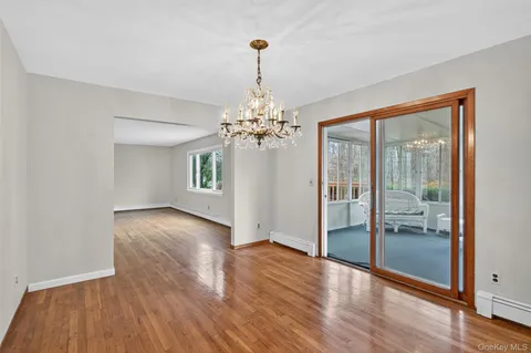 a view of a room with wooden floor chandelier and a window