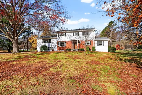 a view of large house with a big yard and large trees
