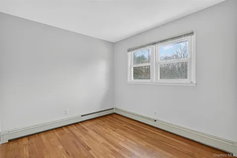 a view of a big room with wooden floor and a window