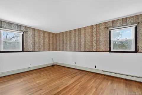 a view of an empty room with wooden floor