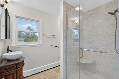 a bathroom with a granite countertop sink a toilet a mirror and shower