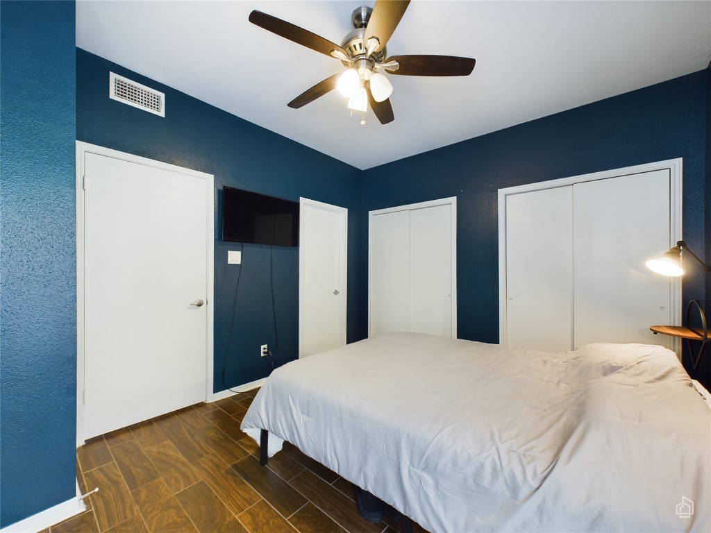 2450 Wickersham Lane, Unit 501 Austin, TX 78741 - Photo 11 of 21 a bedroom with a bed and a ceiling fan