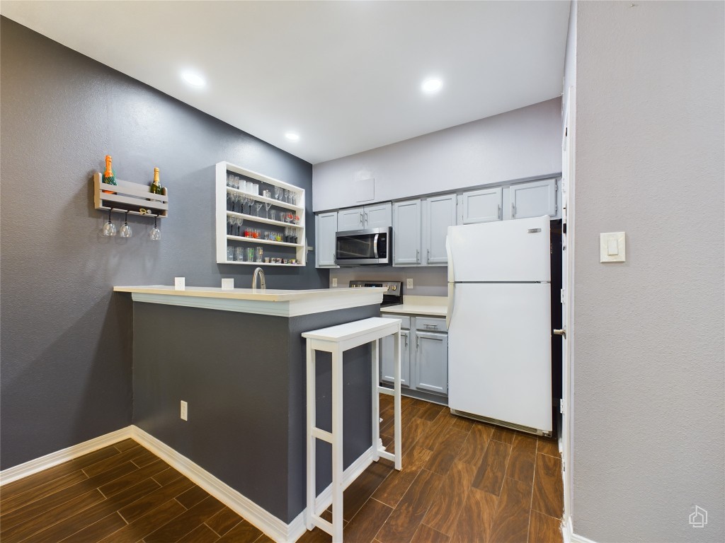 2450 Wickersham Lane, Unit 501 Austin, TX 78741 - Photo 6 of 21 a kitchen with refrigerator cabinets and wooden floor