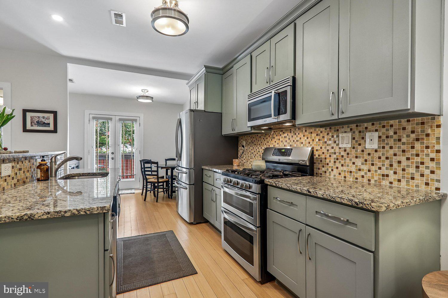 911 L Street Northeast Washington, DC 20002 - Photo 12 of 48 a kitchen with stainless steel appliances granite countertop a sink dishwasher stove refrigerator and cabinets
