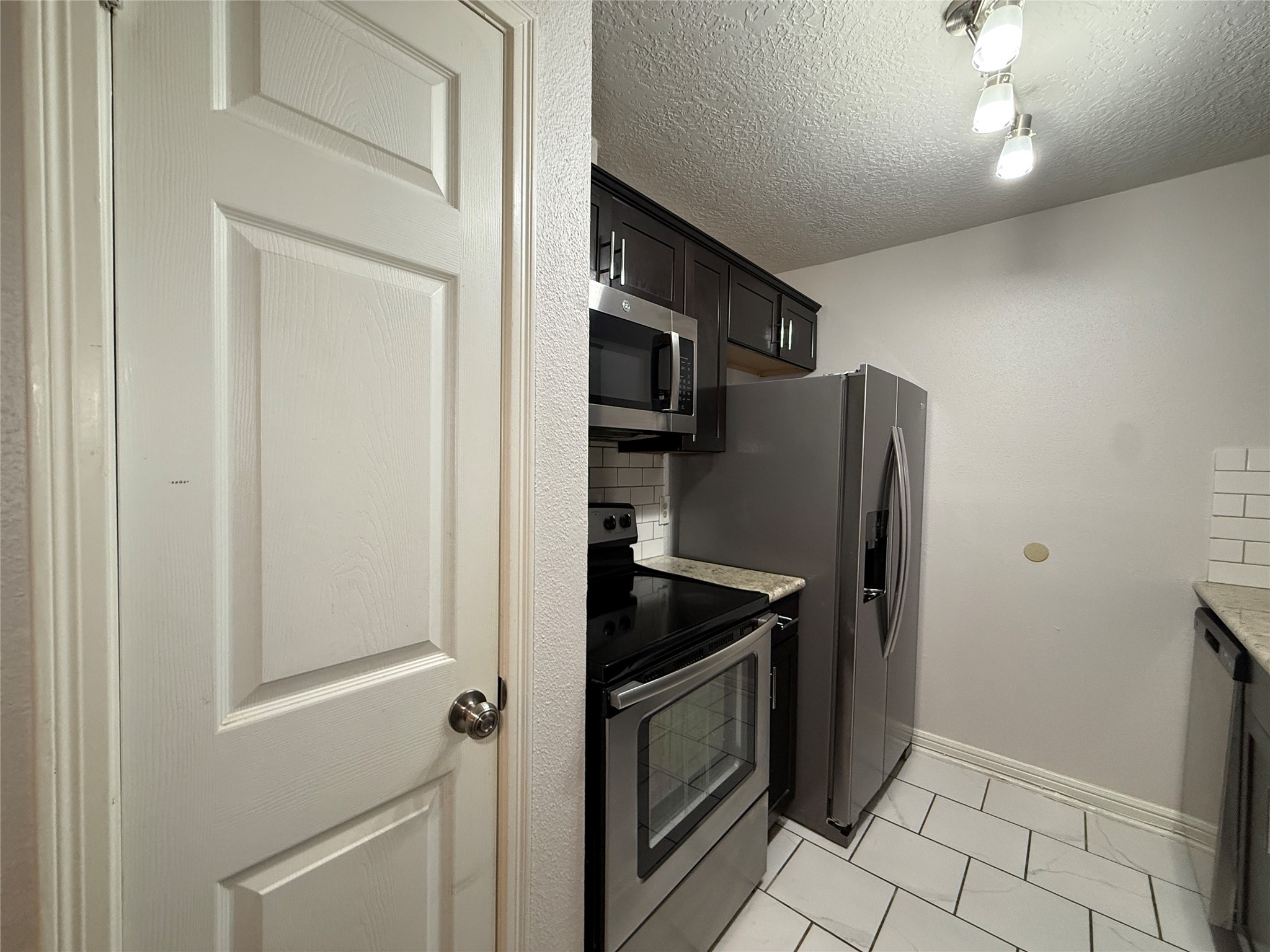 2125 Augusta Drive, Unit 83 Houston, TX 77057 - Photo 12 of 34 a kitchen with stainless steel appliances granite countertop a refrigerator and a stove