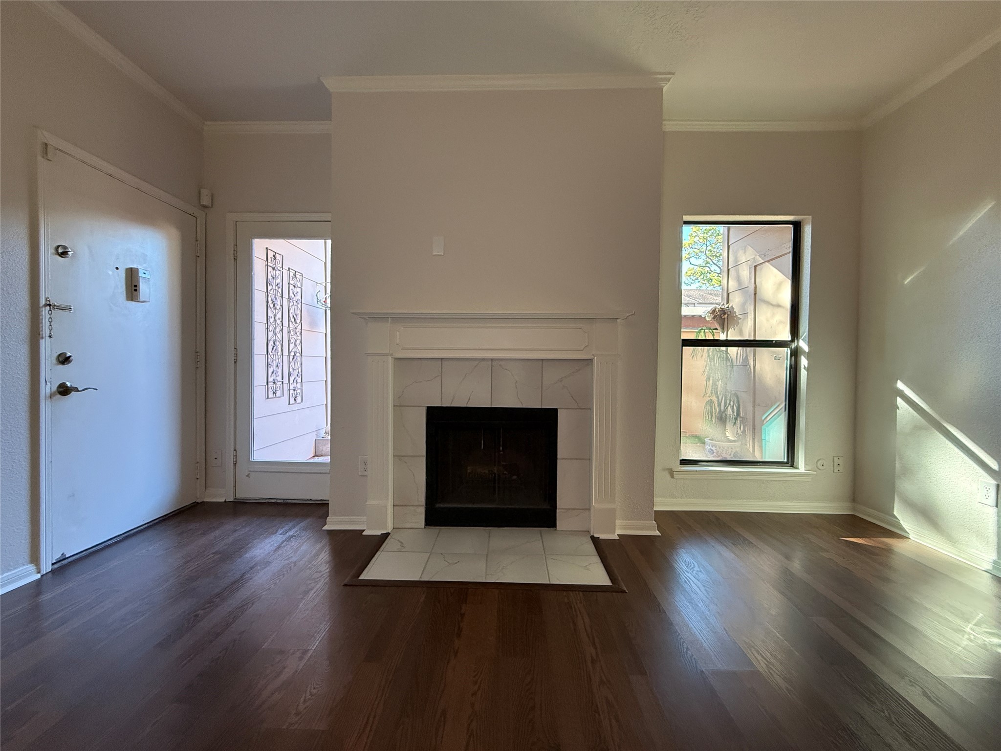 2125 Augusta Drive, Unit 83 Houston, TX 77057 - Photo 8 of 34 an empty room with wooden floor fireplace and windows