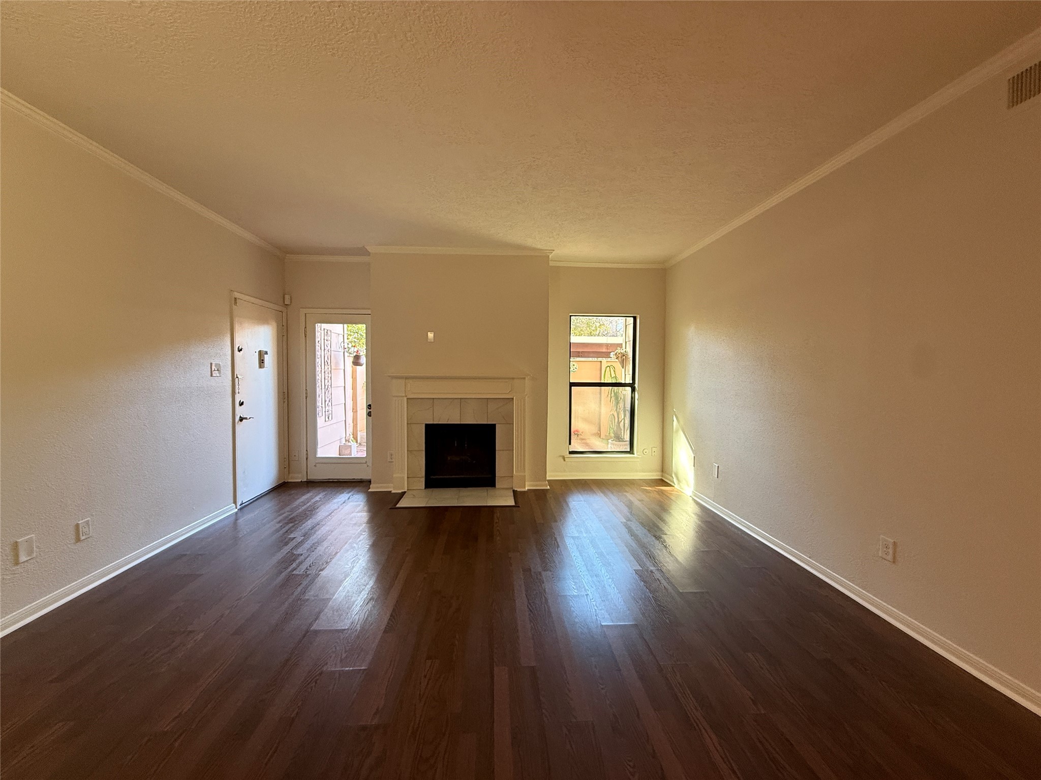 2125 Augusta Drive, Unit 83 Houston, TX 77057 - Photo 9 of 34 an empty room with wooden floor and fireplace