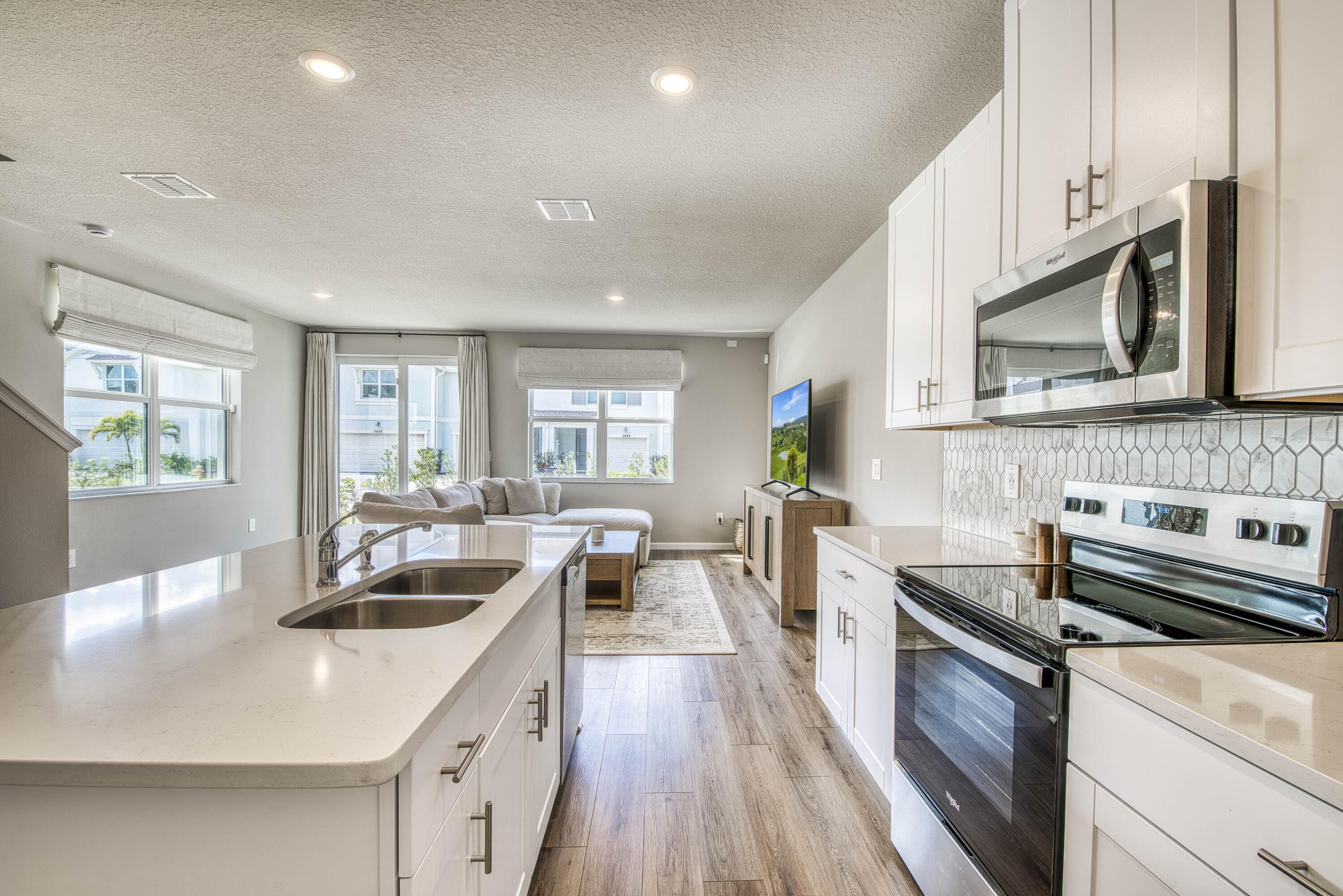 5735 Southeast Edgewater Circle Stuart, FL 34997 - Photo 7 of 39 a kitchen with stainless steel appliances a sink a stove a chimney a sink and cabinets