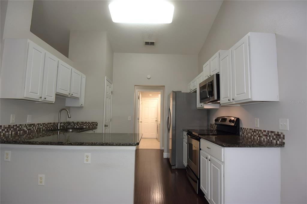 12042 Linden Drive Spring Hill, FL 34608 - Photo 14 of 41 a kitchen with stainless steel appliances granite countertop a stove a sink and a microwave