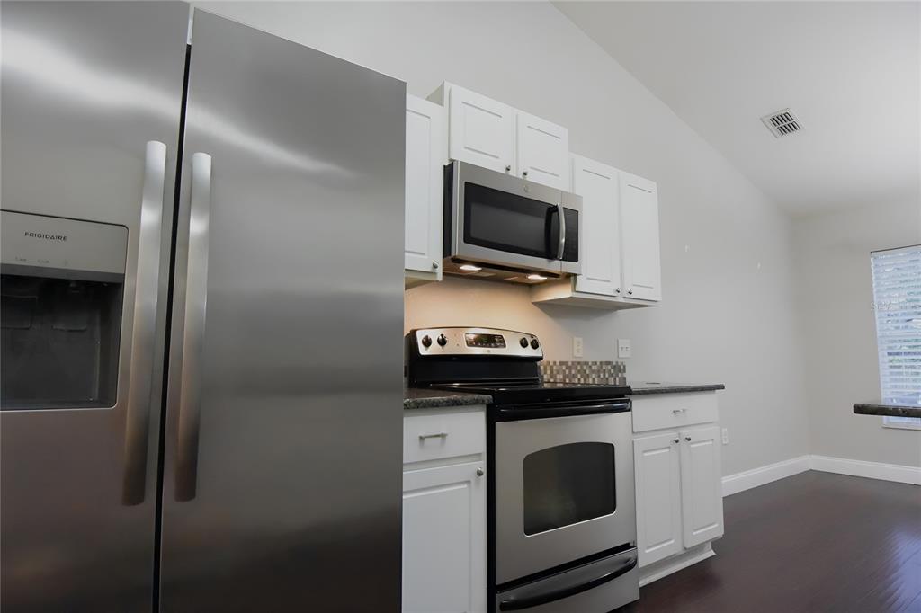 12042 Linden Drive Spring Hill, FL 34608 - Photo 15 of 41 a kitchen with a stove and a microwave