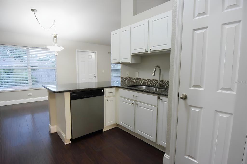12042 Linden Drive Spring Hill, FL 34608 - Photo 17 of 41 a kitchen with granite countertop white cabinets and black appliances