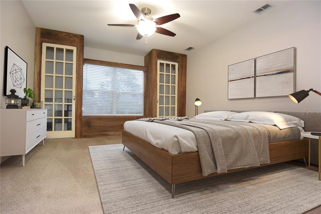 12042 Linden Drive Spring Hill, FL 34608 - Photo 20 of 41 a spacious bedroom with a large bed and a chandelier fan